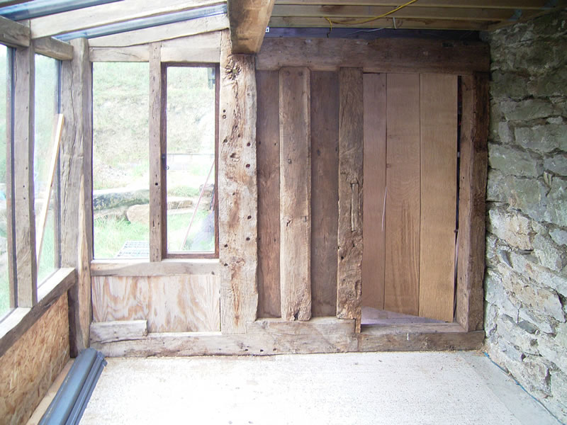 Plank and muntin style end wall with distressed ledge and braced door