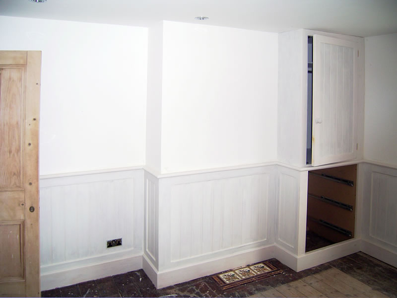 MDF T and G dado panelling and cupboard including drawer fronts split to match panelling
